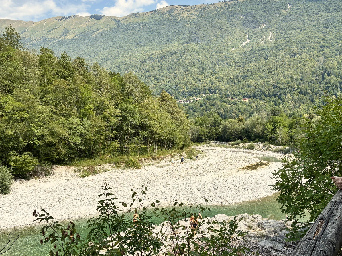 View of Nadiža river with pebble banks surrounded by green trees and hills 